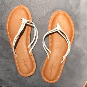 Tan and white flip flops